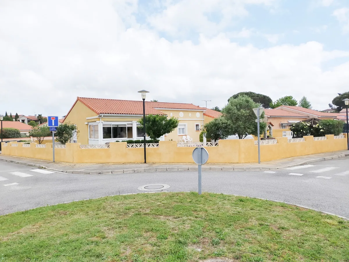 Après : le même mur de clôture nettoyé et remis en teinte ocre, assortie à la façade de la maison