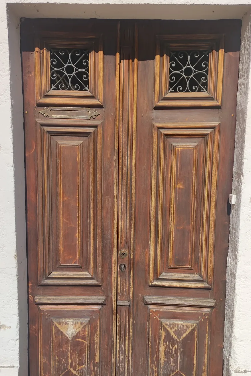 Avant : porte d'entrée en bois à la finition brune écaillée et délavée