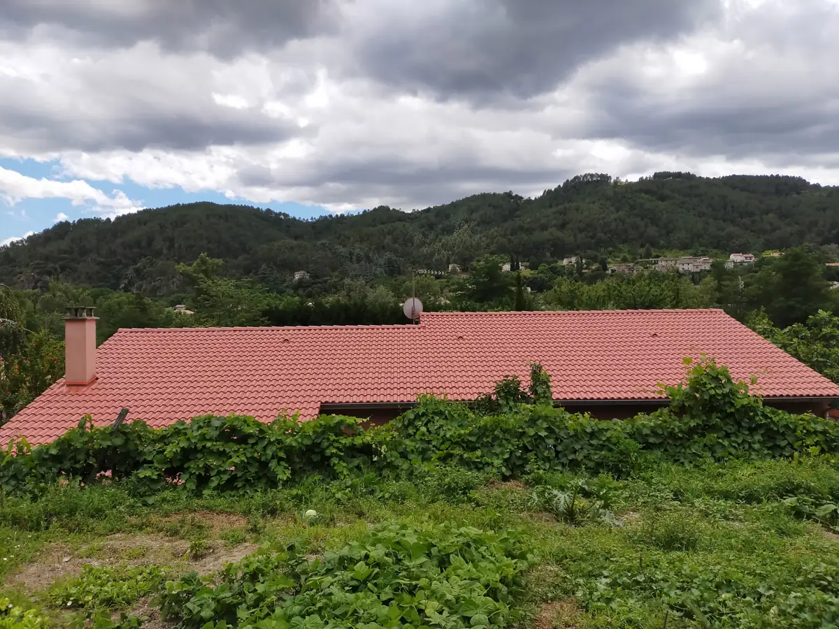 Après : toiture d'un rouge vif et uniforme après traitement coloré